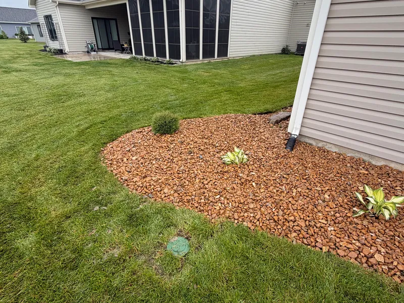 Brown rock drainage bed running along a house foundation