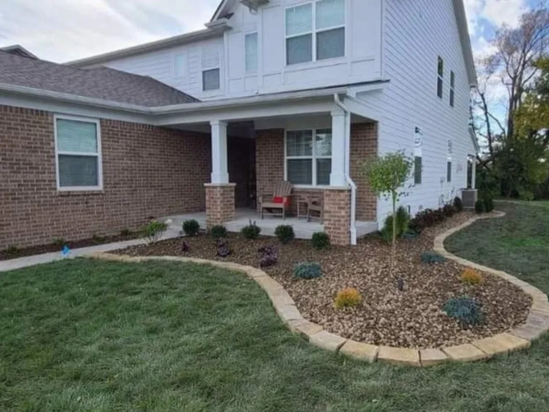 Brown decorative rock landscape bed with paver edging