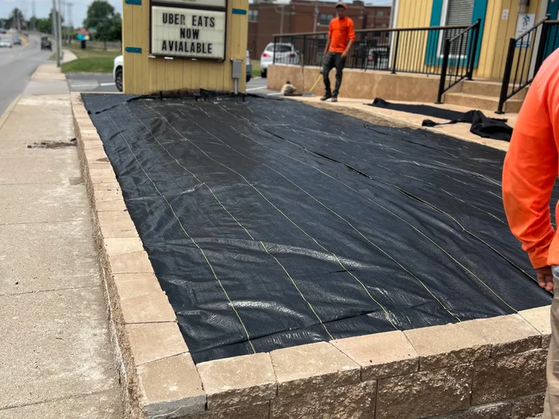 Paver base and block wall course being set for an outdoor living area