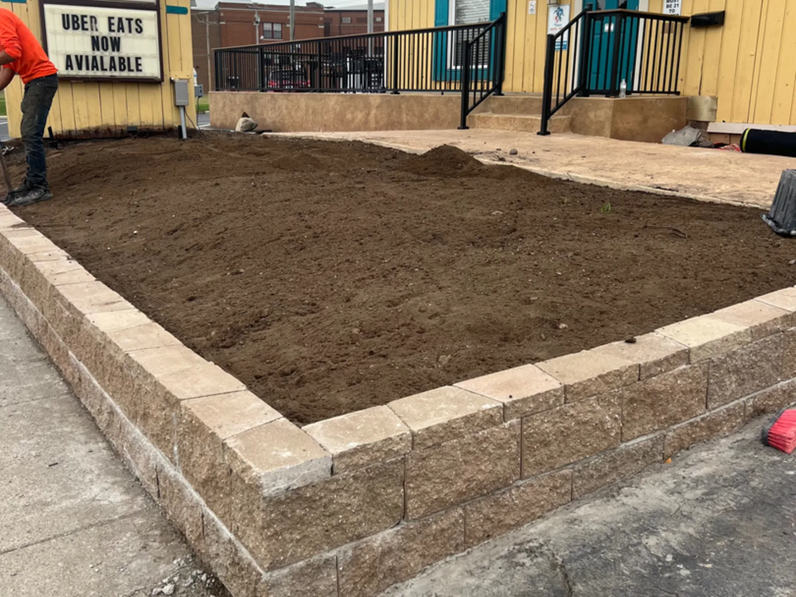Commercial retaining wall block installation with drainage aggregate visible behind the wall face near Fort Wayne, Indiana