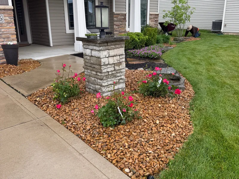 Front porch flower bed finished in river rock with new perennials