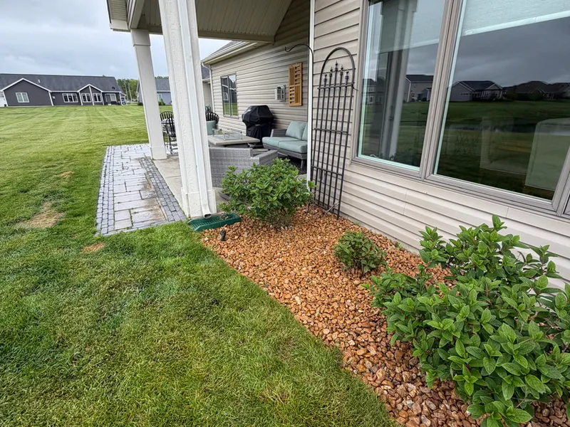 River rock drainage bed running along a house foundation to carry downspout water away