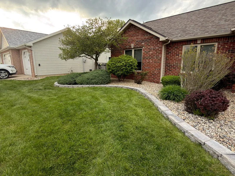 Stone edged landscape bed at a brick ranch home