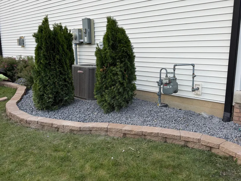 White rock landscape bed planted with arborvitae